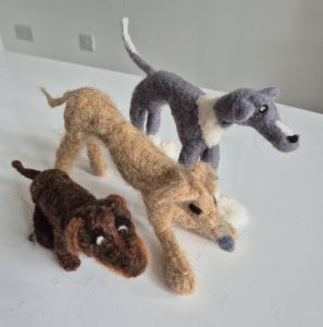Needle felted dogs dark brown dachsund and beige and silver whippets.  Felted pet dogs. Workshops in Needle Felt in Stroud. 