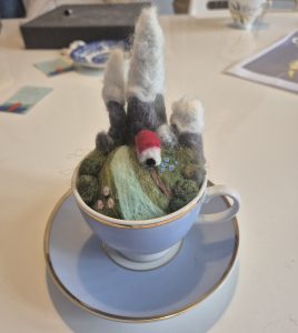Needle felted alpine mountain scene in a teacup, learn how to felt in a workshop.